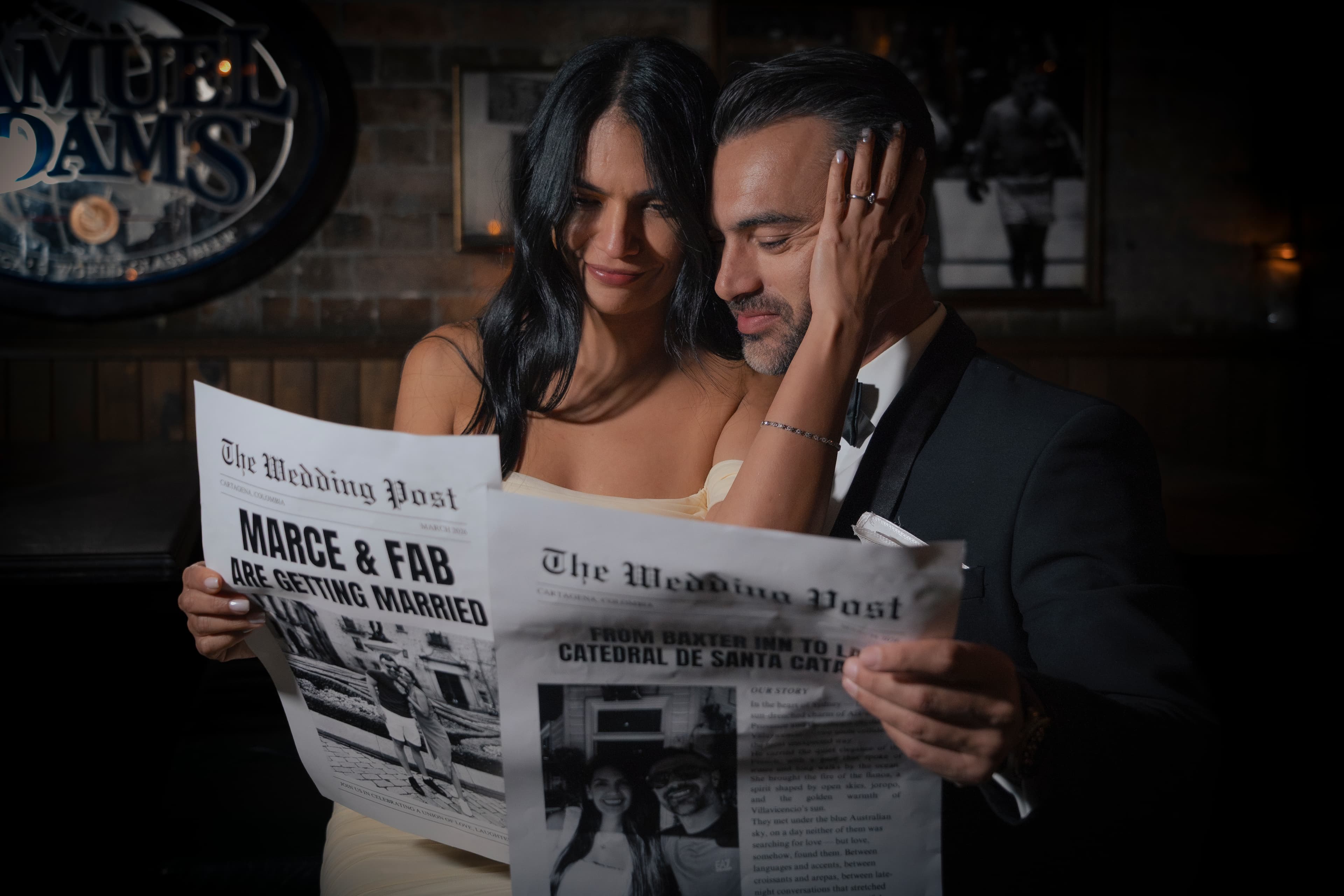 Couple in formal attire holding a wedding announcement newspaper in a dimly lit bar.